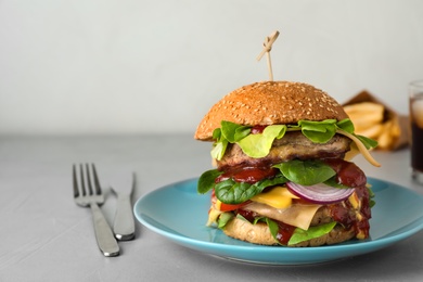 Plate with tasty burger served on table. Space for text