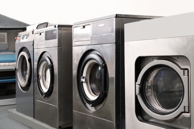 Photo of Row of modern washing machines in dry-cleaning