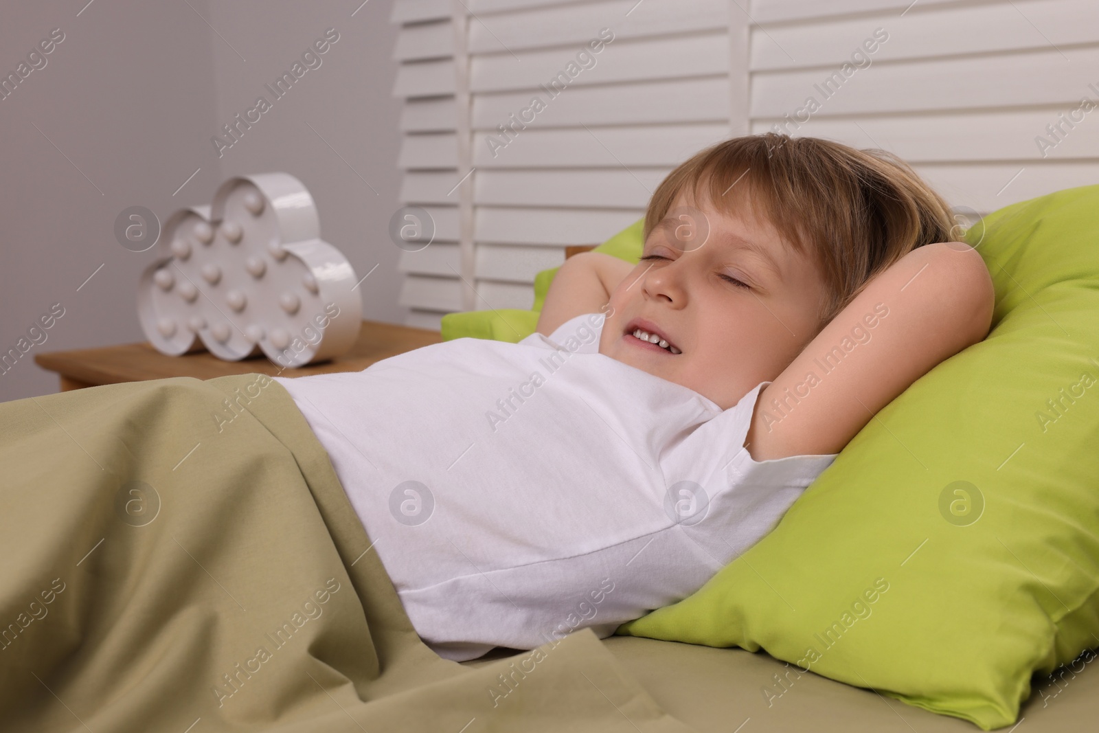 Photo of Little boy snoring while sleeping in bed indoors
