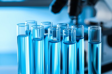 Photo of Test tubes with light blue liquid in laboratory, closeup