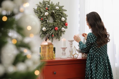 Photo of Woman lighting up candles at home. Christmas time