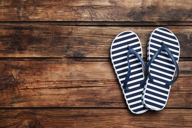 Photo of Stylish flip flops on wooden background, flat lay. Space for text