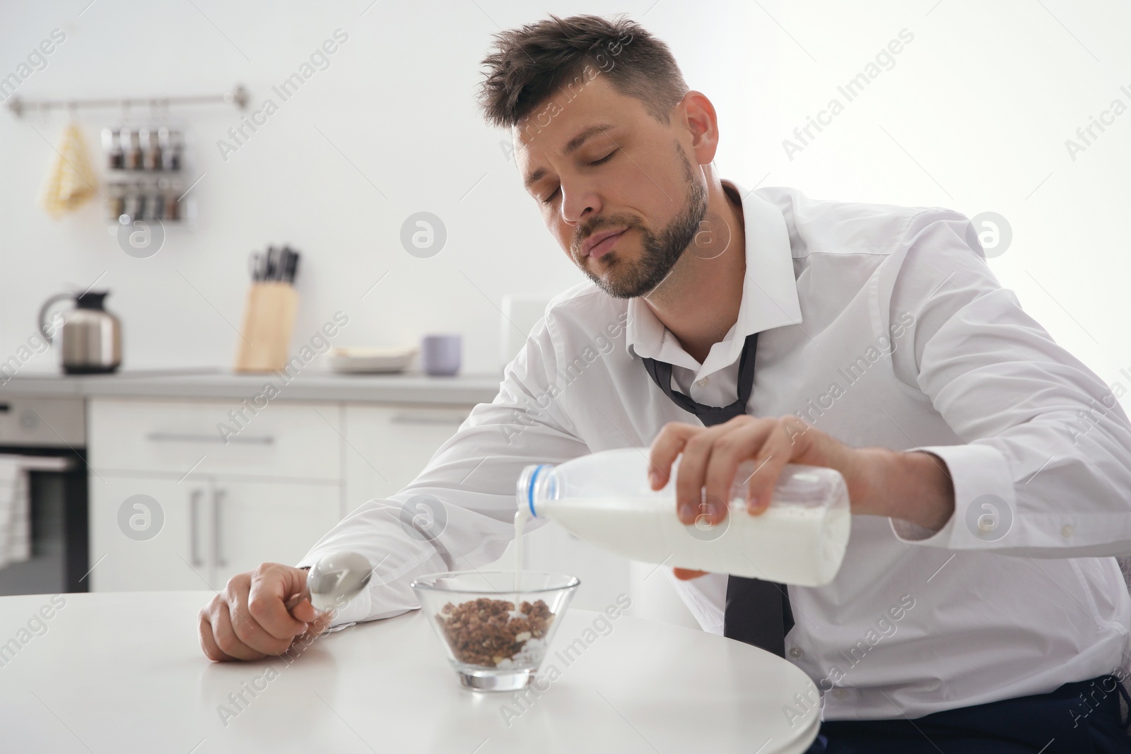 Photo of Sleepy man cooking breakfast at home in morning