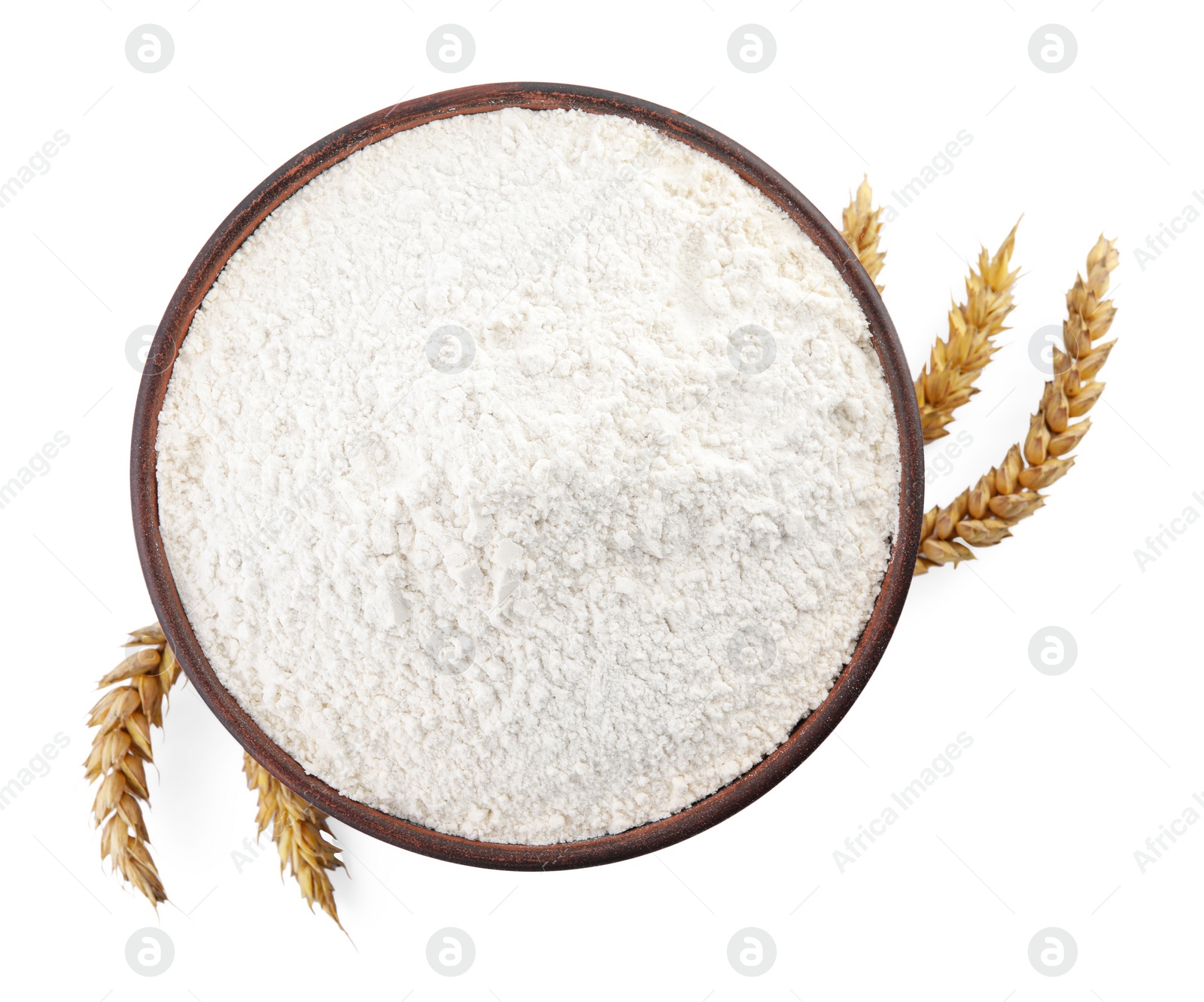 Photo of Bowl with wheat flour and spikelets on white background, top view