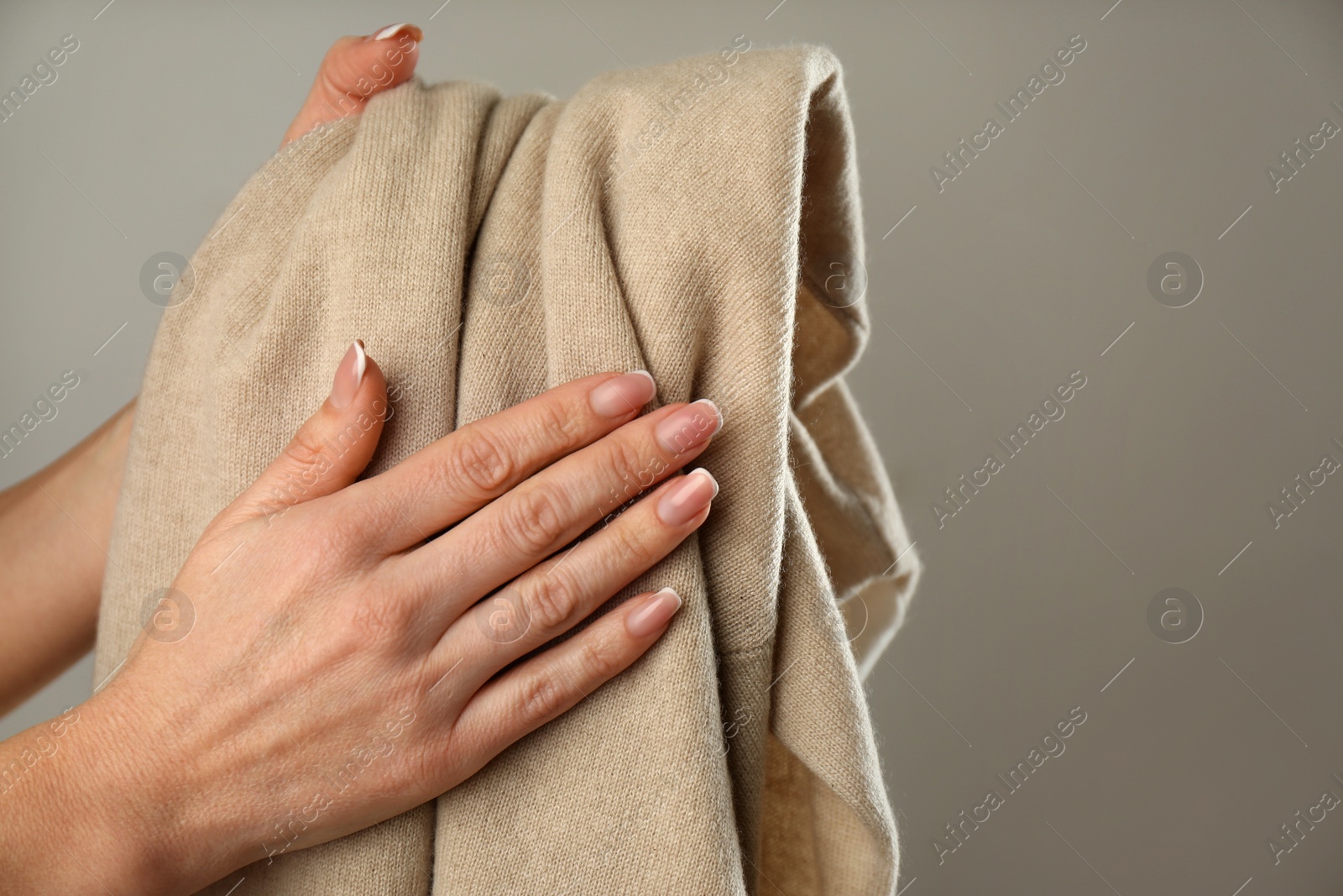 Photo of Woman with cashmere sweater on beige background, closeup