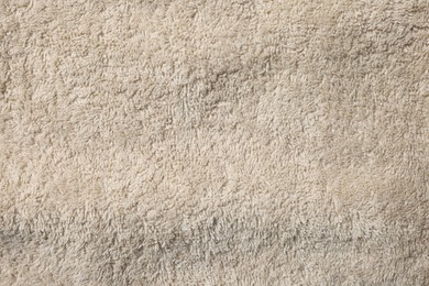 Photo of Texture of soft beige fabric as background, top view