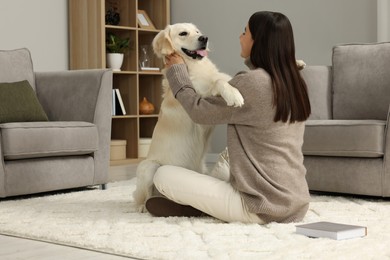 Photo of Woman with cute Labrador Retriever dog on floor at home. Adorable pet