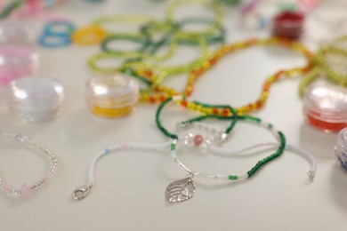 Beautiful handmade beaded jewelry and supplies on white table