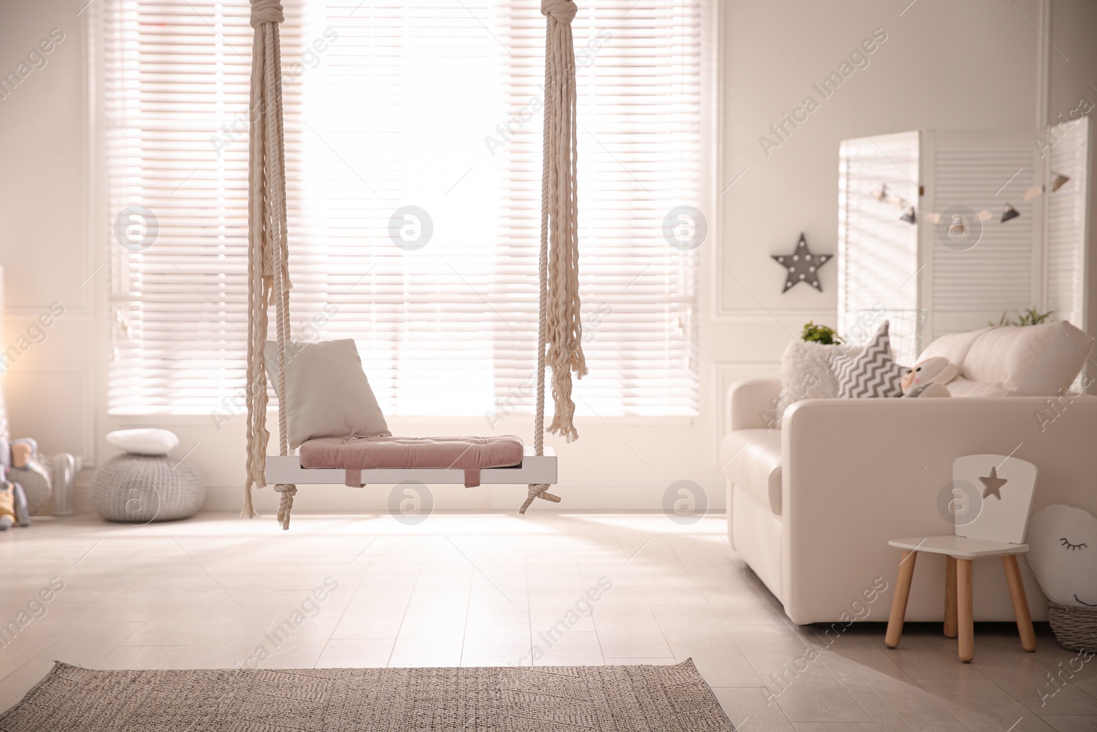 Photo of Beautiful swing with pillow in living room. Stylish interior design