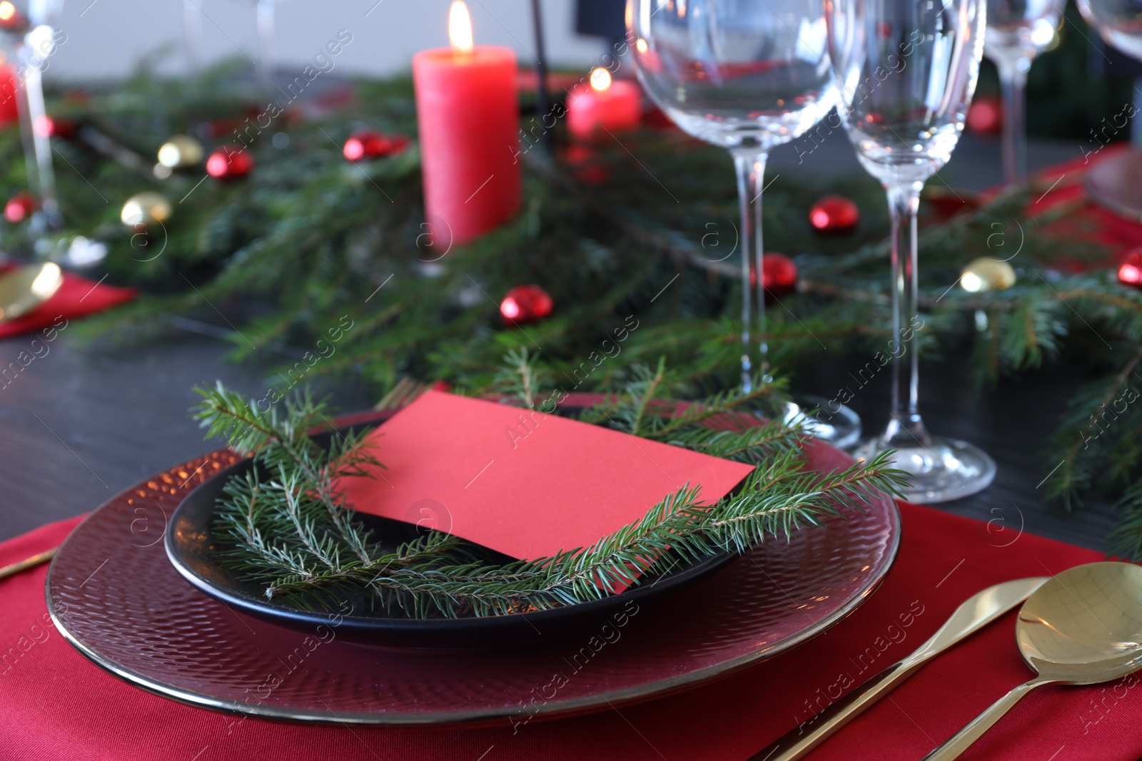 Photo of Elegant Christmas place setting with blank card and festive decor on table, closeup