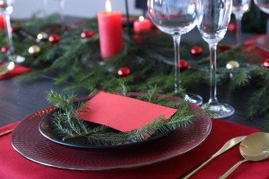 Photo of Elegant Christmas place setting with blank card and festive decor on table, closeup