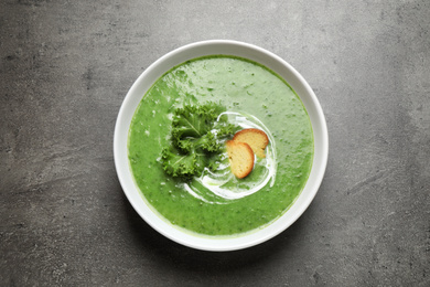 Photo of Tasty kale soup on grey table, top view