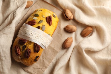Delicious pumpkin bread with pecan nuts on tablecloth, flat lay. Space for text