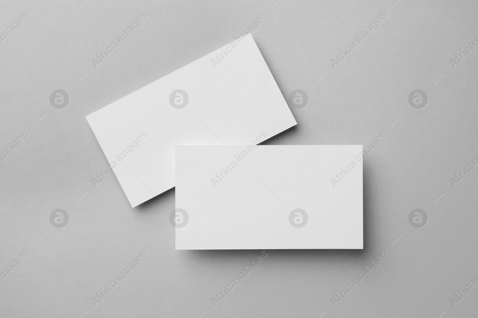 Photo of Blank business cards on light grey background, flat lay. Mockup for design