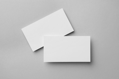 Blank business cards on light grey background, flat lay. Mockup for design