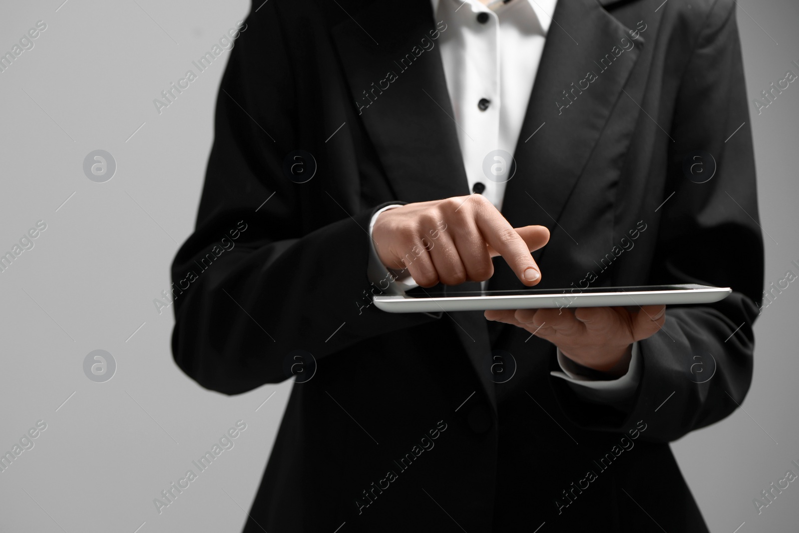 Photo of Closeup view of woman using modern tablet on grey background