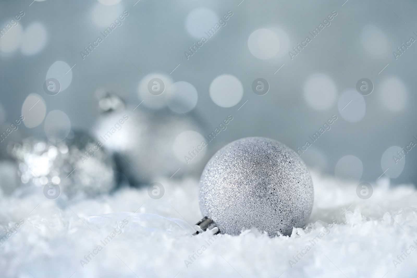 Image of Beautiful silver Christmas ball on snow, bokeh effect