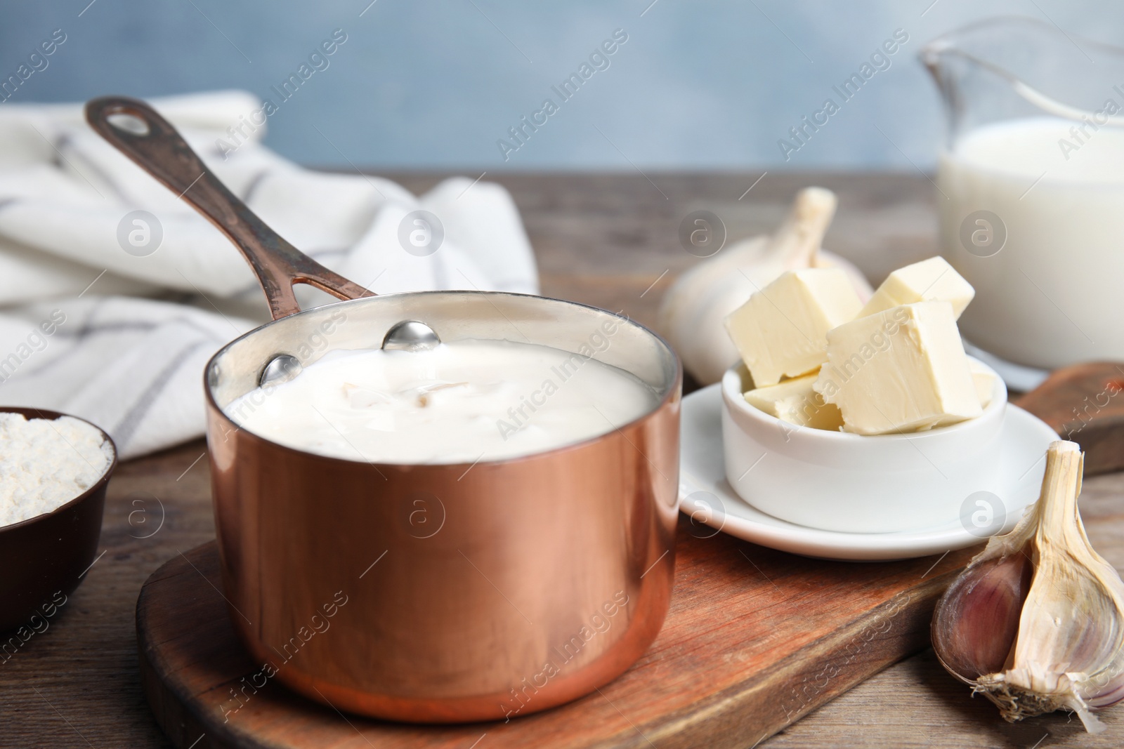 Photo of Delicious creamy sauce in pan on wooden table