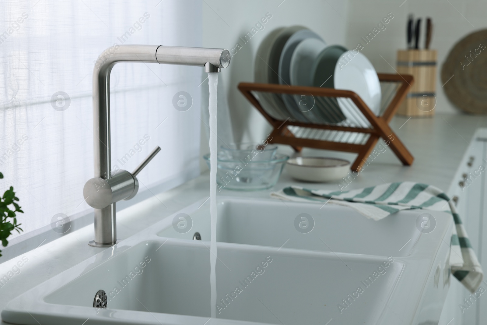Photo of Stream of water flowing from tap in kitchen, space for text