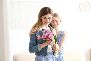 Teenage daughter congratulating happy woman on Mother's Day at home