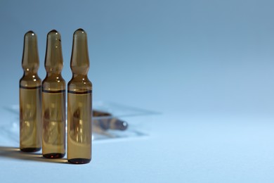 Photo of Brown pharmaceutical ampoules with medication on light background. Space for text