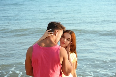 Photo of Happy young couple posing near sea on beach