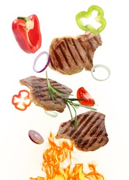 Tasty grilled meat, different vegetables and fire flame on white background