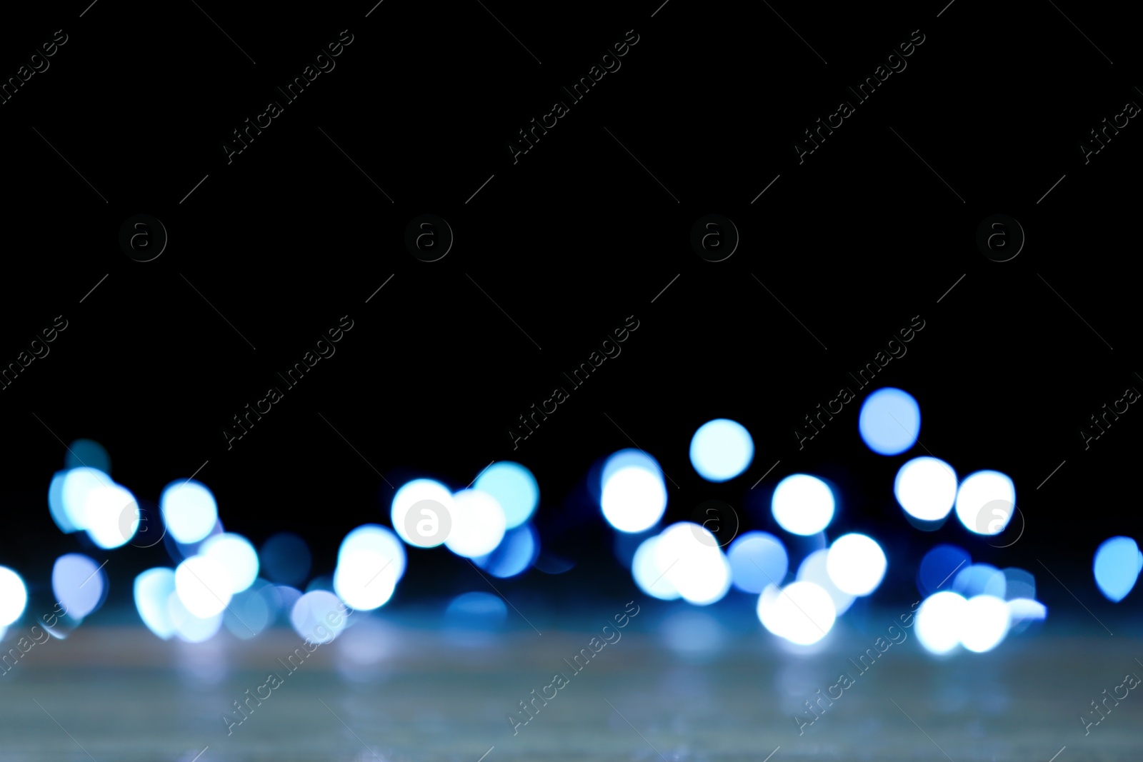 Photo of Blurred view of beautiful lights on black background. Bokeh effect