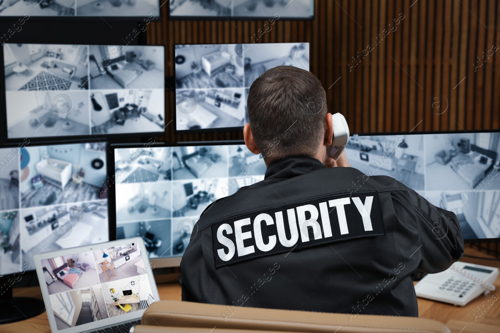 Photo of Security guard talking on telephone at workplace