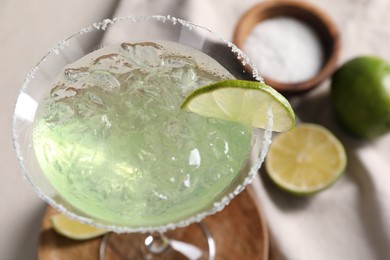 Photo of Delicious Margarita cocktail with ice cubes in glass and lime, closeup