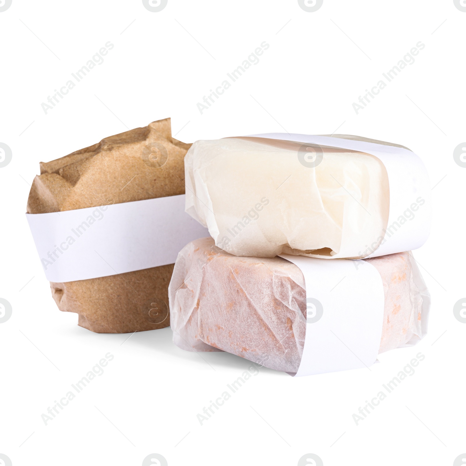 Photo of Solid shampoo bars wrapped in parchment on white background
