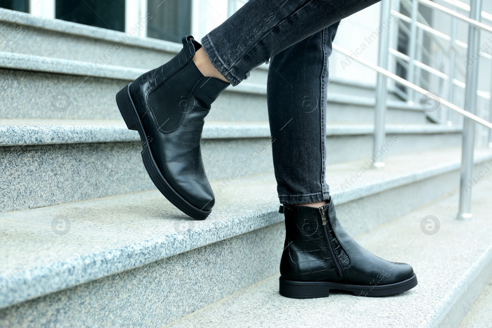 Photo of Woman in stylish boots on stairs outdoors, closeup