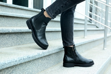 Woman in stylish boots on stairs outdoors, closeup