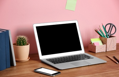 Laptop with blank screen on office table. Mock up for design