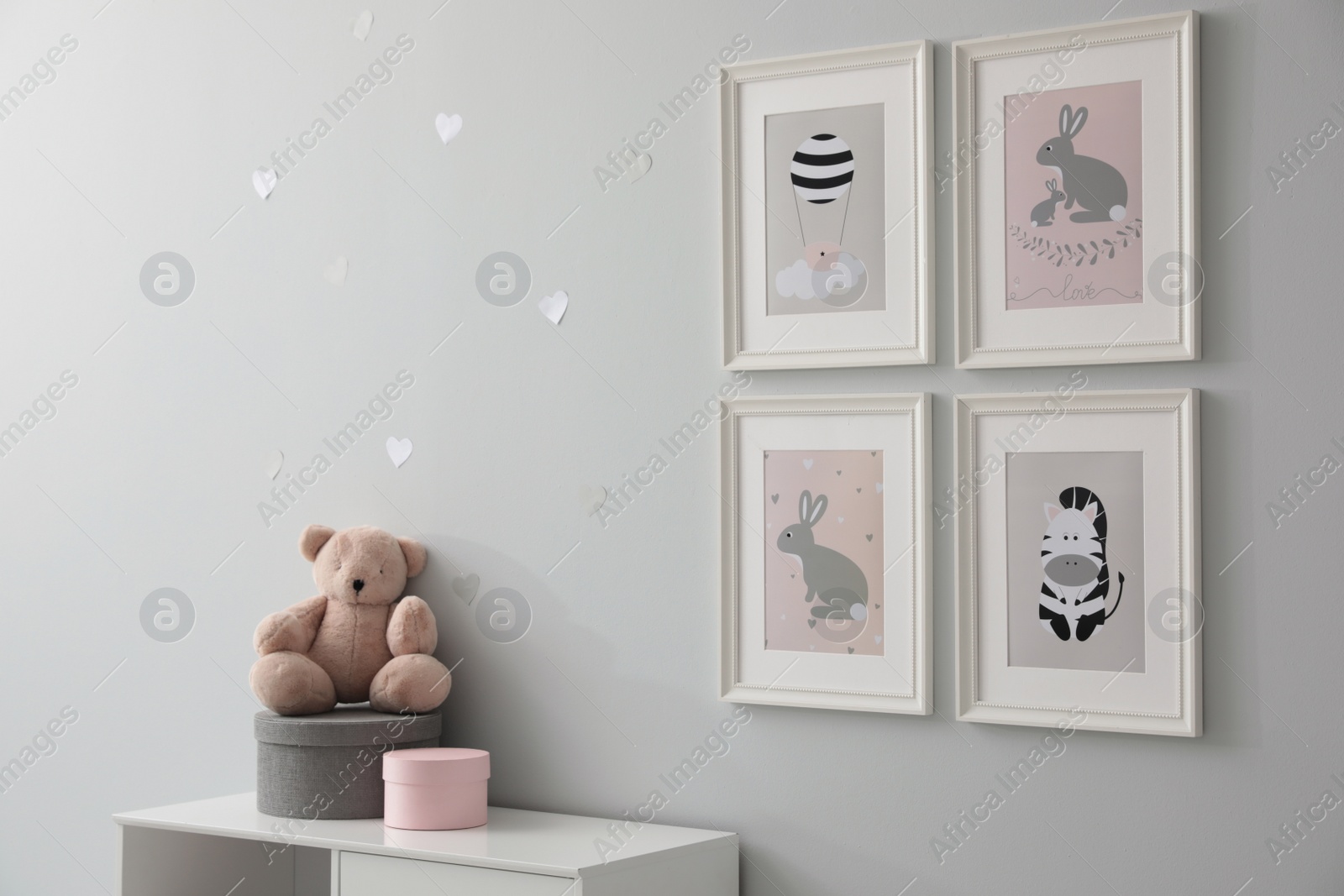 Photo of Stylish baby room interior with chest of drawers and cute pictures on wall