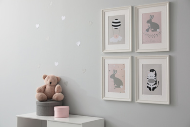 Stylish baby room interior with chest of drawers and cute pictures on wall