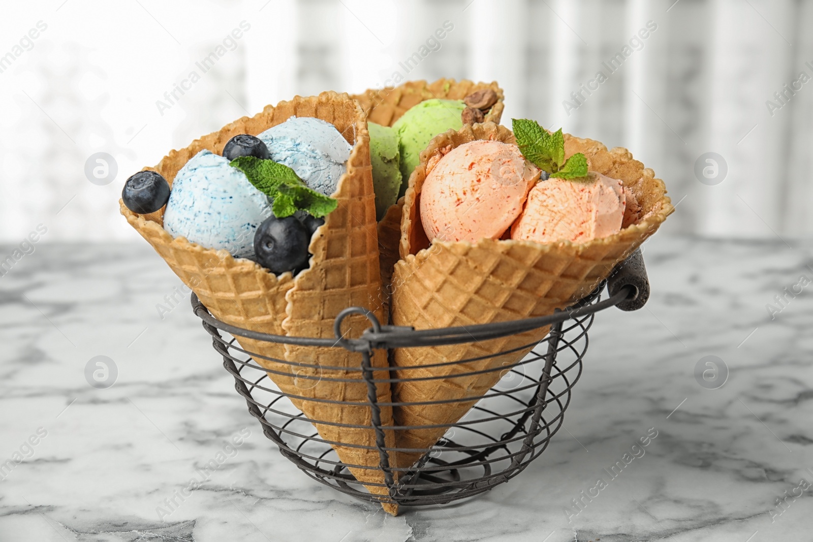 Photo of Delicious ice creams served in basket on table