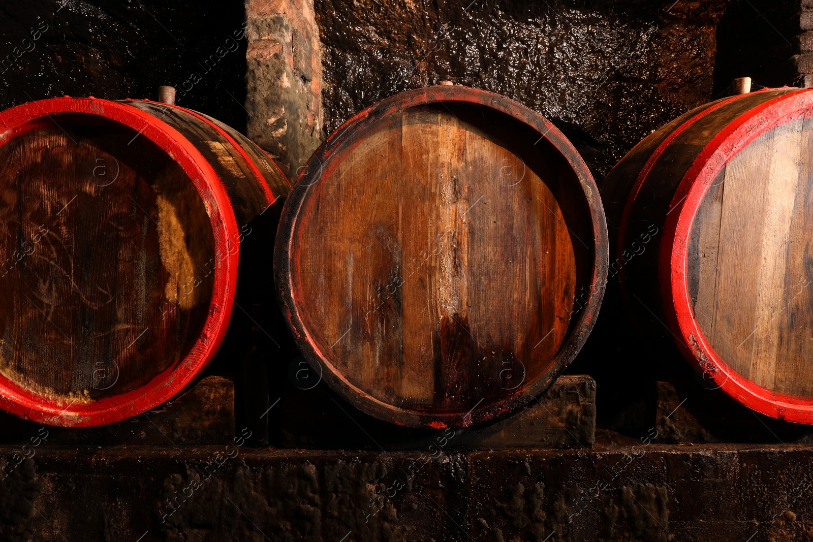 Photo of Wooden barrels with alcohol drinks in cellar