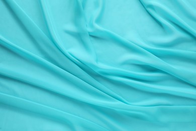 Photo of Beautiful turquoise tulle fabric as background, top view