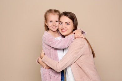 Photo of Portrait of young woman and her daughter on color background