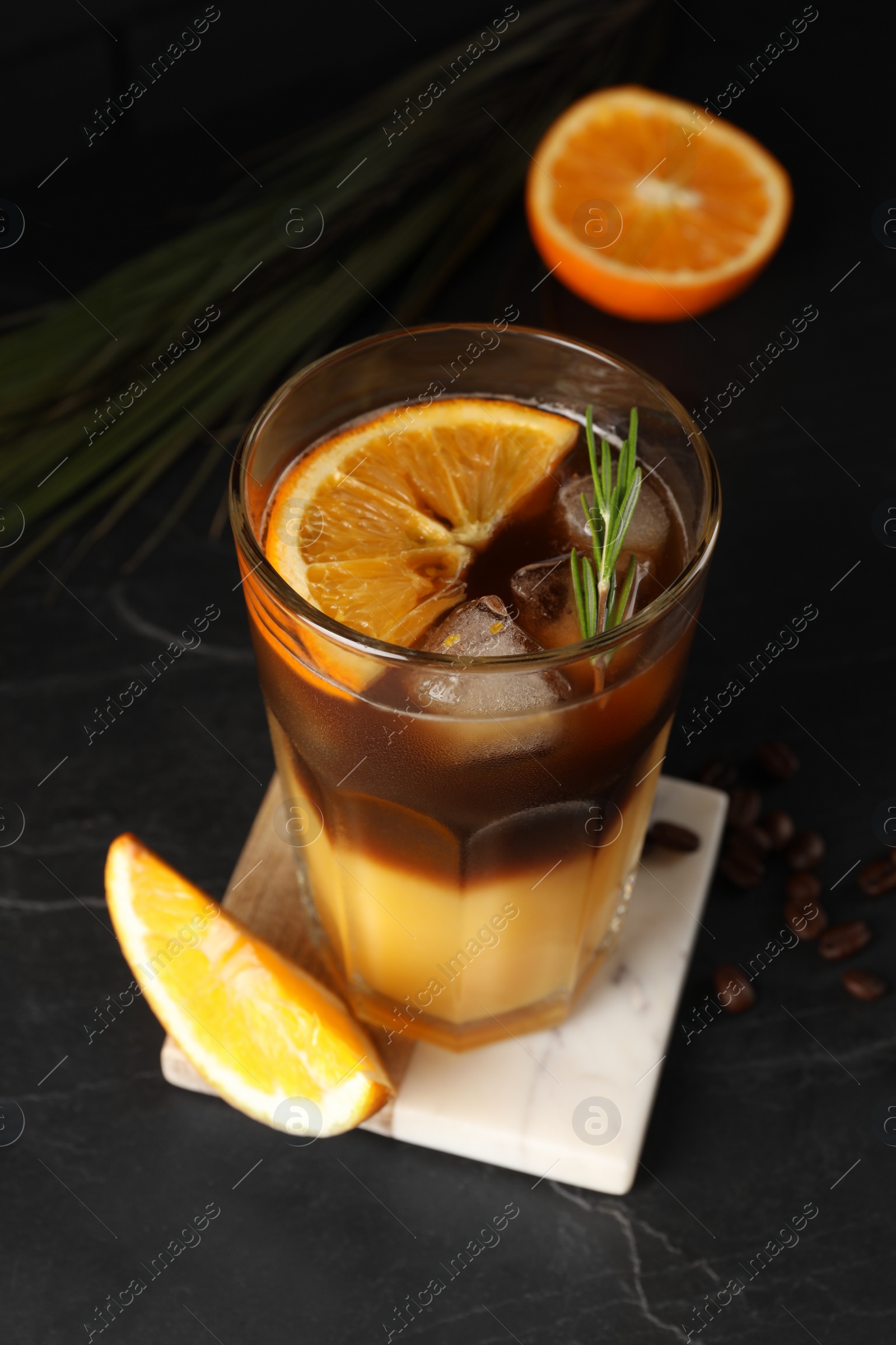 Photo of Tasty refreshing drink with coffee and orange juice on grey table