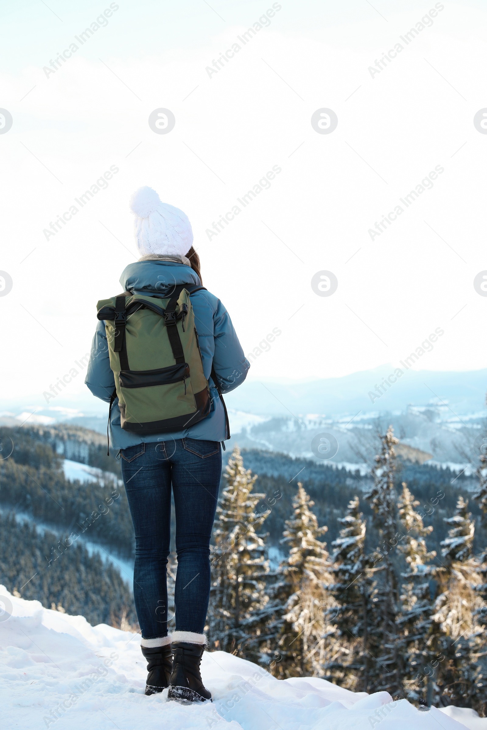 Photo of Woman with backpack enjoying mountain view during winter vacation