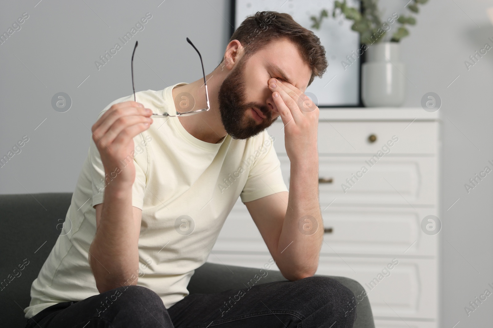 Photo of Overwhelmed man with glasses suffering at home