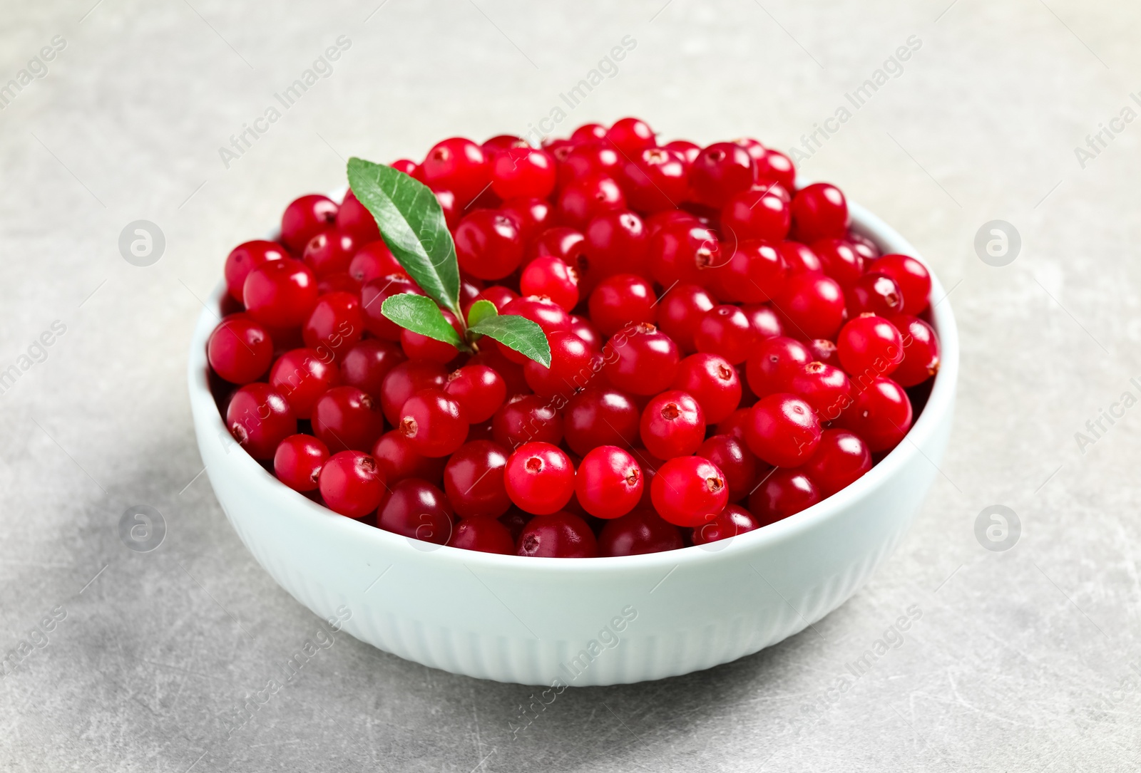 Photo of Tasty ripe cranberries on grey table, closeup