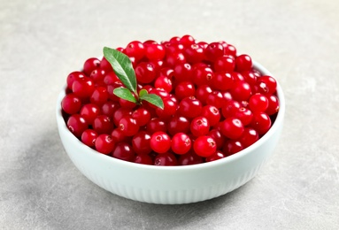 Tasty ripe cranberries on grey table, closeup