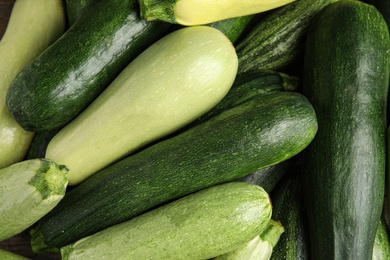 Photo of Top view of fresh ripe zucchini as background, closeup