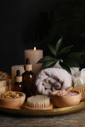 Photo of Spa composition. Brush, bottles and sea salt on grey textured table