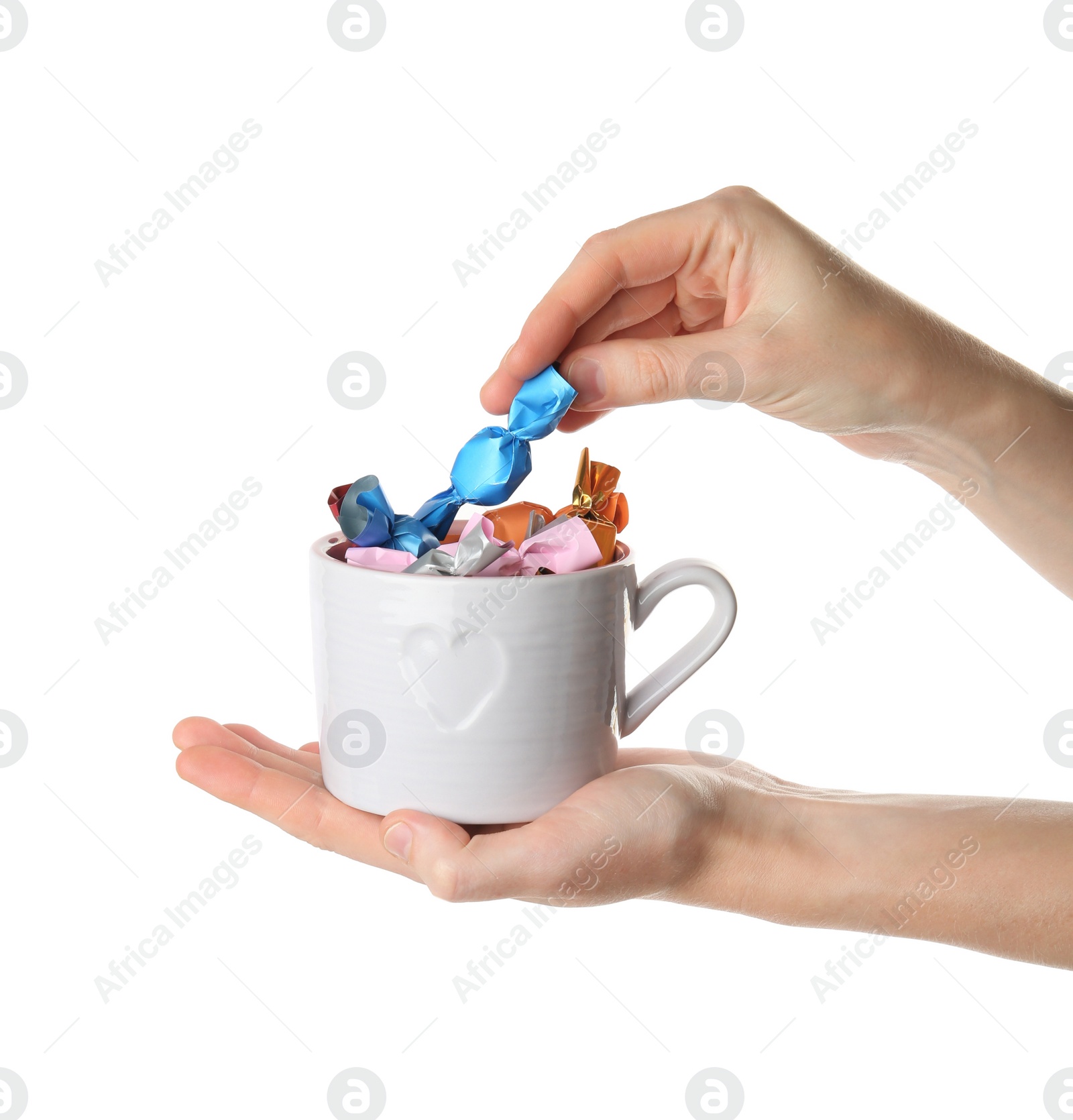 Photo of Woman taking candy in light blue wrapper from cup isolated on white, closeup