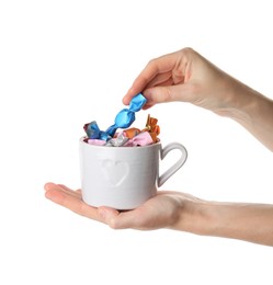 Photo of Woman taking candy in light blue wrapper from cup isolated on white, closeup