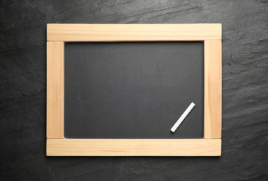 Empty blackboard with chalk on slate background, top view. Space for text